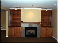 Remodeled basement with custom built-in bookcases and beautiful slate-surround fireplace